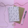 Kerstkaart met illustraties van candycanes, met een roze achtergrond