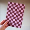 Een vel papier met een roze en rood geblokt patroon.