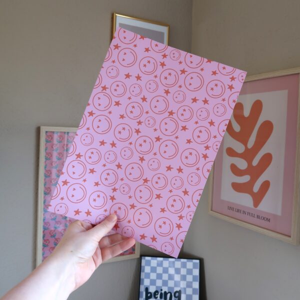 los vel papier met roze en oranje patroon van lachende gezichtjes wat gebruikt kan worden als achtergrondje voor je journal of scrapbook project