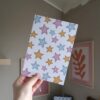 Vel papier met illustraties van roze, gele en blauwe sterren.