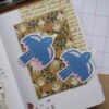 Een losse vinyl sticker met een illustratie van een blauwe vogel.