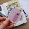 Close up van een sticker met de illustratie van een roze kat.