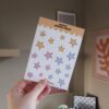 Een hand die een stickervel met sterretjes vast houdt.