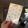 Een hand die een stickervel met sterretjes vast houdt.
