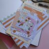 Een afbeelding van een lente journal kit vol met papiertjes en stickers bedoelt om mee te journallen of te scrapbooken.
