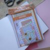 Een afbeelding van een lente journal kit vol met papiertjes en stickers bedoelt om mee te journallen of te scrapbooken.
