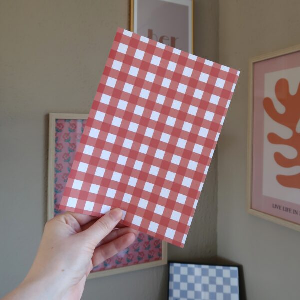 Een vel papier met een rood gingham patroon, bedoelt voor het journallen of scrapbooken.