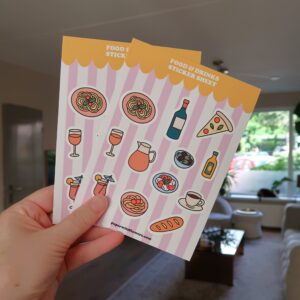 Stickervel met illustraties van eten en drinken, zoals pizza, pasta, olijven en wijn.