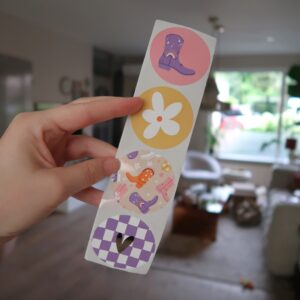 Setje met vier ronde stickers met ieder een eigen design: een roze sticker met een cowboy laars, een gele sticker met een witte bloem, een sticker met meerdere cowboy laarzen en een lila geblokte sticker met een gouden hart.