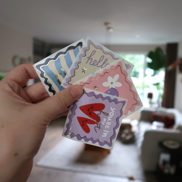 Setje met vier vierkante stickers met verschillende kleurrijke designs.
