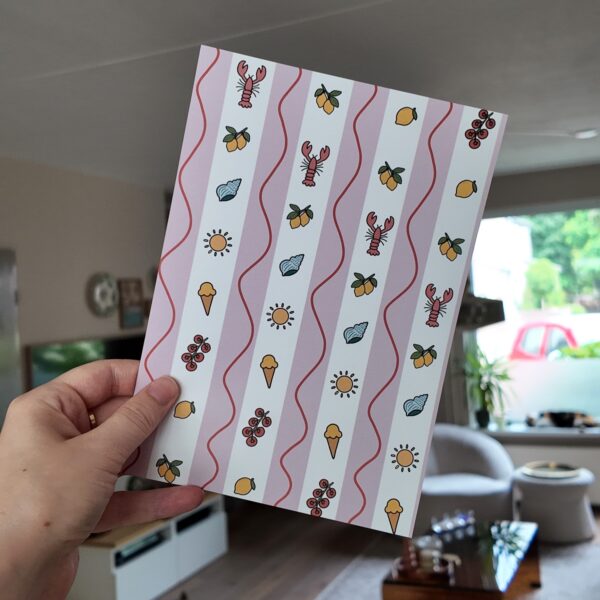 Papier bundel met eigen geïllustreerd papier met afbeeldingen in een zomerse stijl, zoals ijsjes, citroenen en schelpjes.