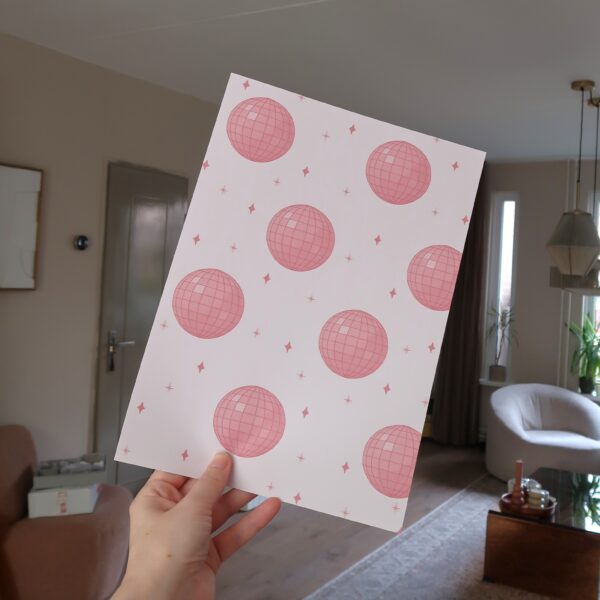 A4 papier met een patroon van roze discoballen en sterretjes.