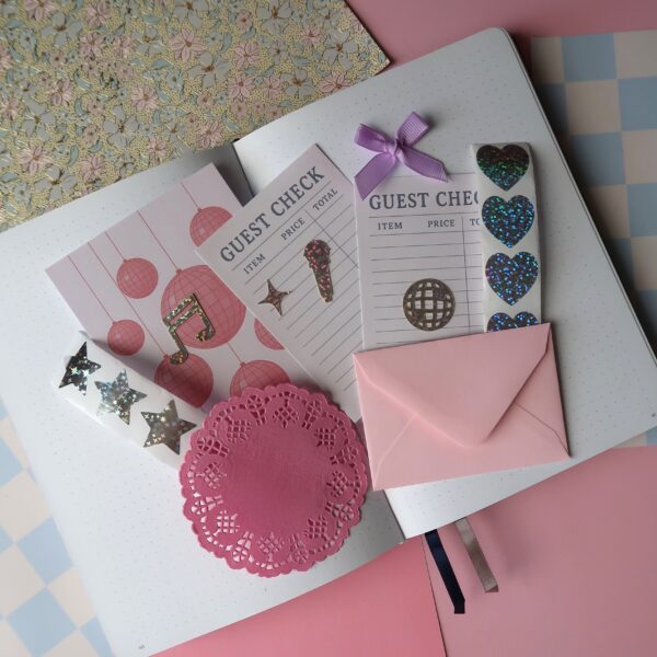 Inhoud van een journal kit met het thema party, met onder anderen stickervellen, achtergrondjes, stickers en andere journal spullen.