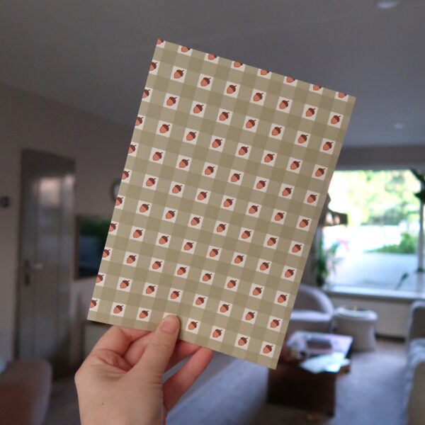Vel papier met illustraties van groen gingham en eikeltjes.