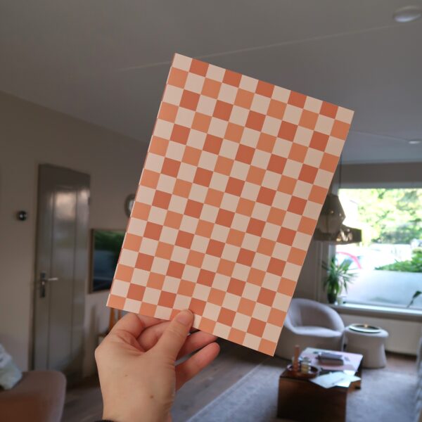 Vel papier met een geruit patroon in bruine en oranje tinten.