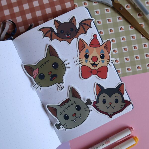 Vijf stickers van illustraties van katten in verschillende Halloween versies, waaronder een zombie, Frankenstein, een vliermuis, een clown en Dracula.