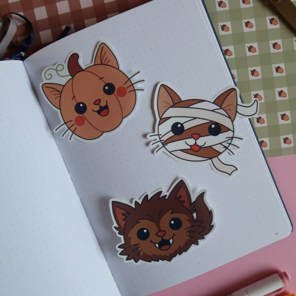 Drie stickers van illustraties van katten in verschillende Halloween versies, waaronder een zombie, Frankenstein, een vliermuis, een clown en Dracula.