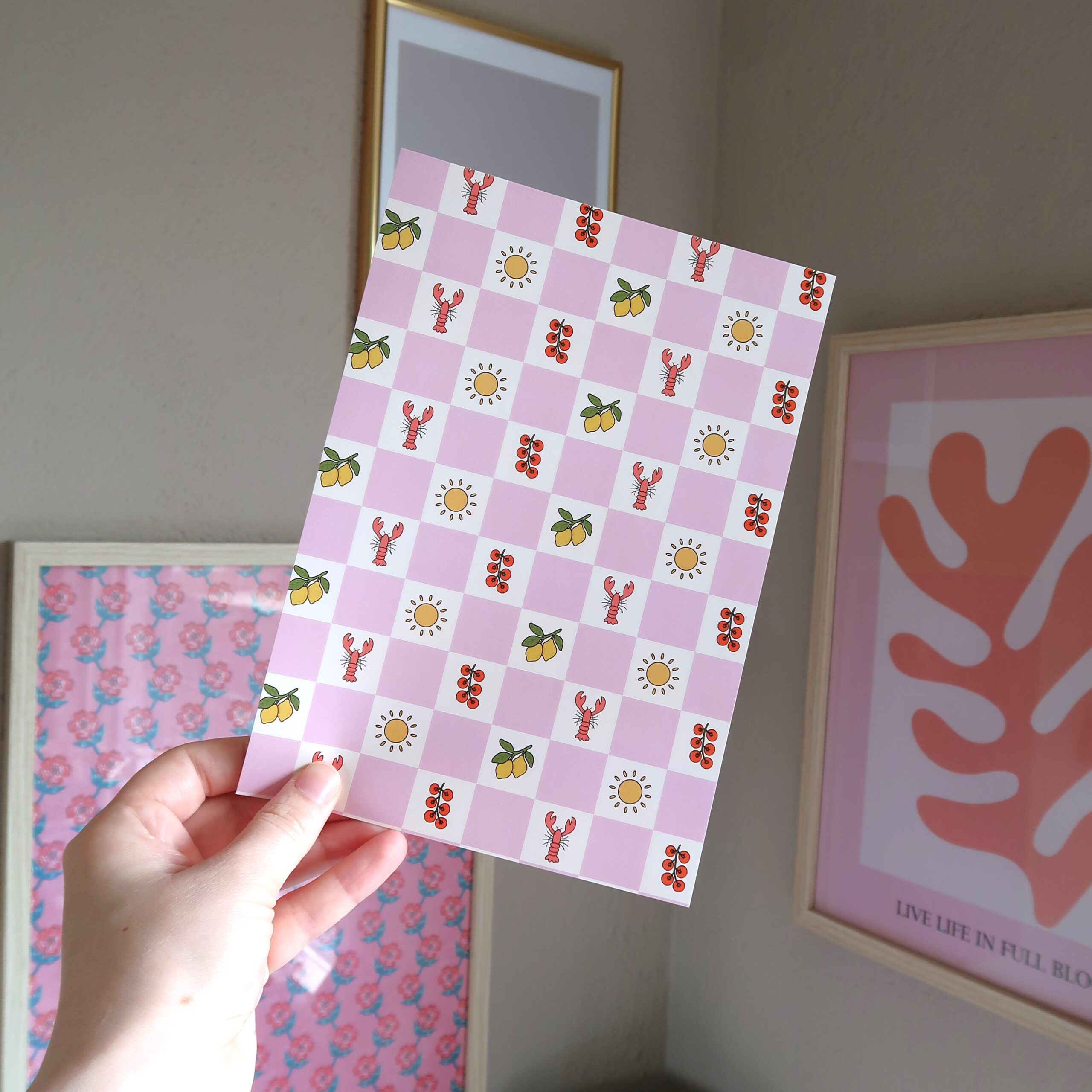 Achtergrond papiertje voor het journallen met een roze en wit geblokt patroon en illustraties van zomerse dingen, zoals kreeft, citroen en zon.