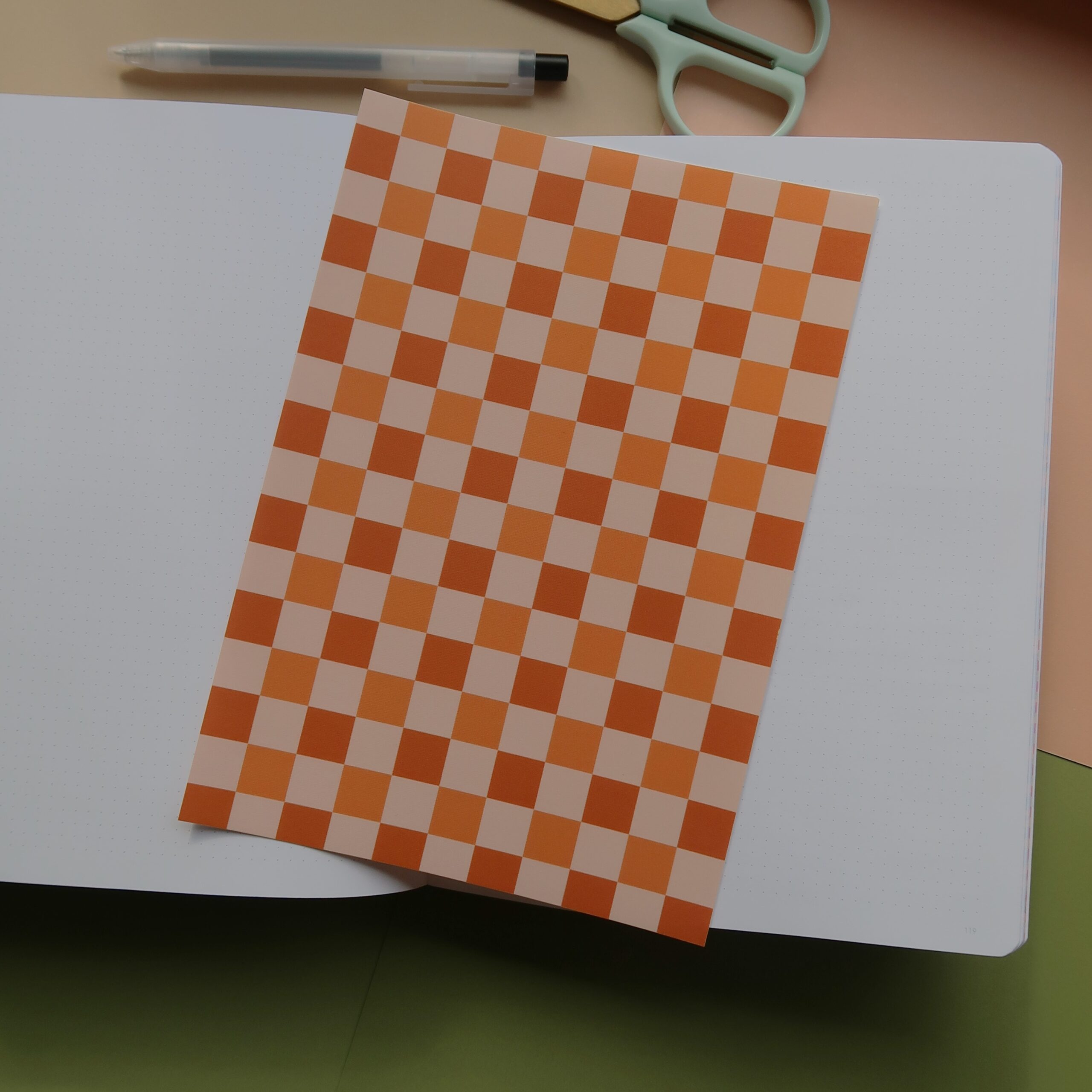 Vel journal papier met een bruin en oranje geblokt patroon.
