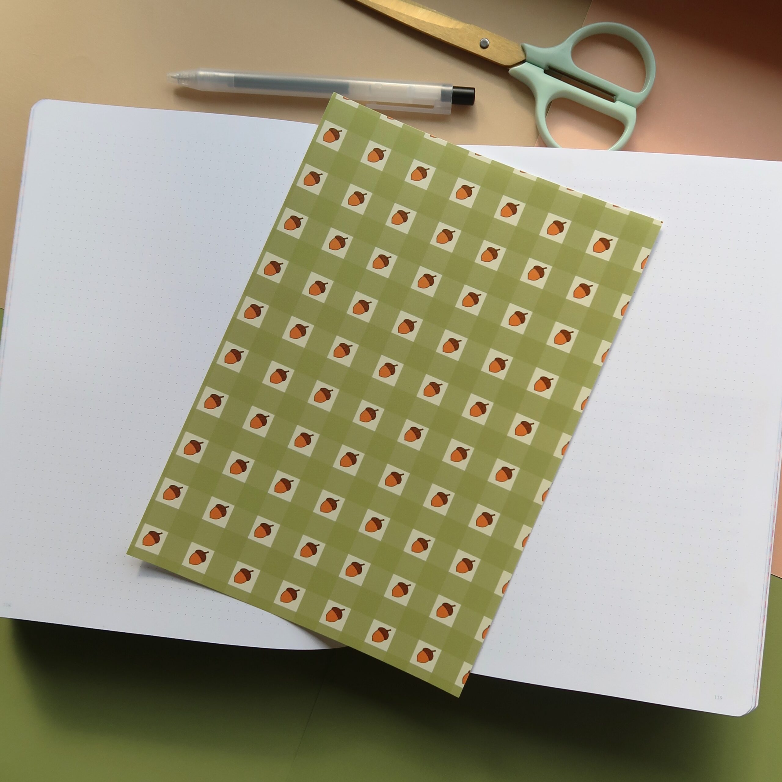 Vel journal papier met groen gingham patroon en eikeltjes.