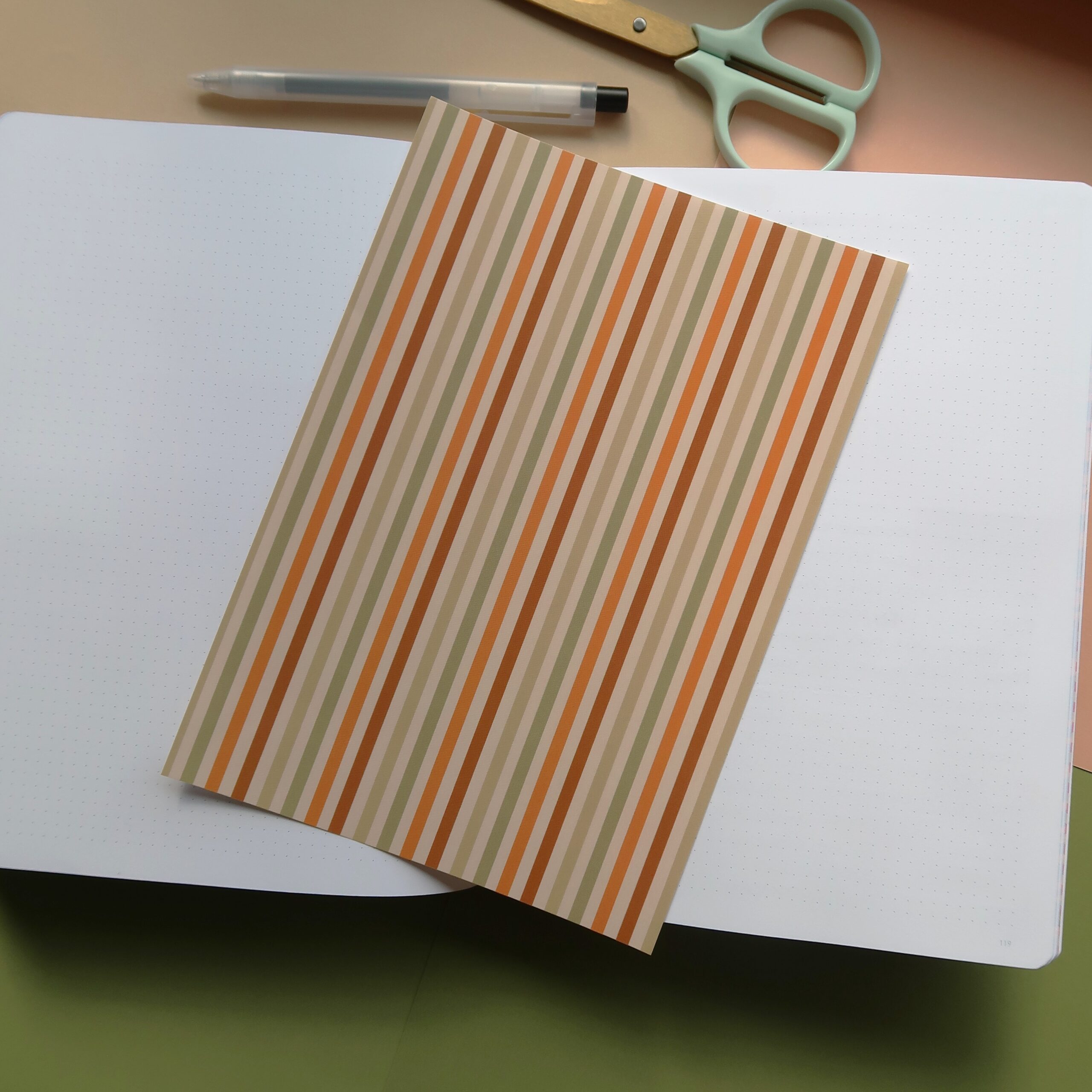 Vel journal papier met een gestreept patroon in herfst kleuren.